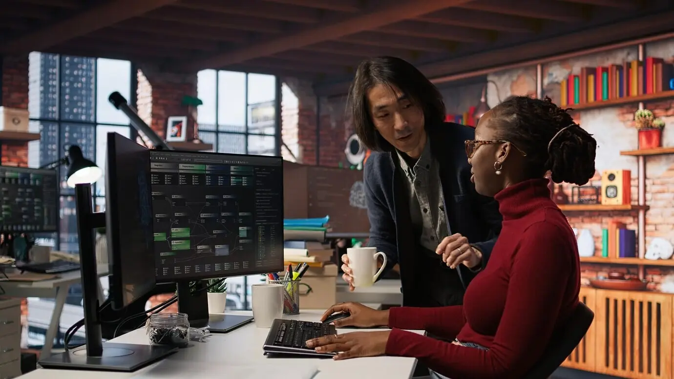 Il CTO supervisore in una startup di intelligenza artificiale porta il caffè a un lavoratore stanco.